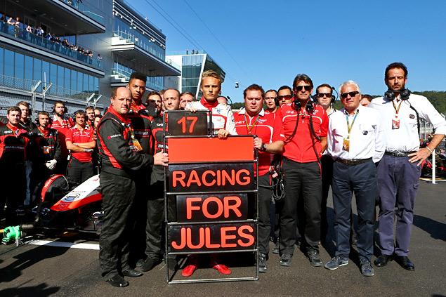 Члены команды Marussia и сотрудники FIA на стартовой решетке