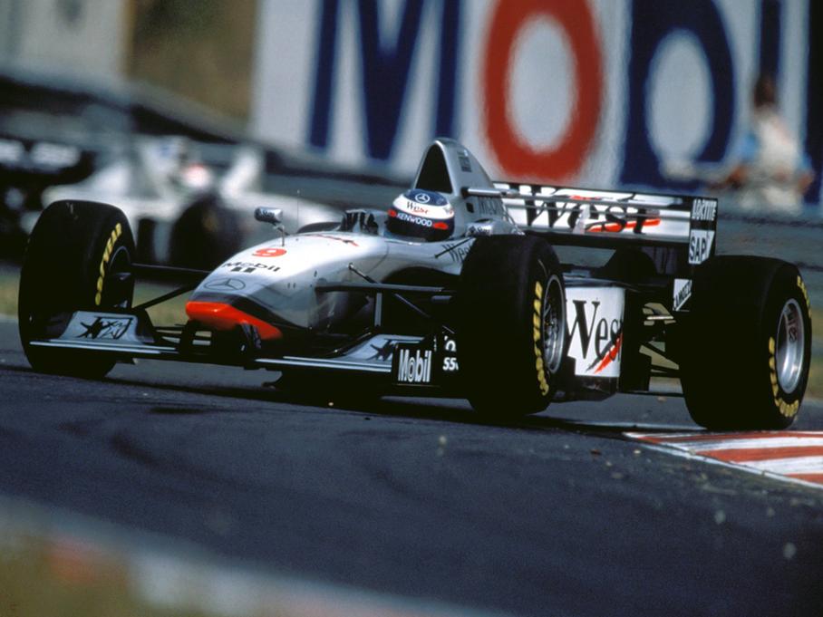 Элегантный McLaren MP4/12 Mercedes-Benz Эдриана Ньюи, который принес Мике Хаккинену в 1998 году чемпионский титул. Самый успешный гоночный конструктор современности — мастер по части аэродинамики. Многие считают Ньюи главным соперником Шумахера — во всяком случае, его машины завоевали даже больше титулов.
