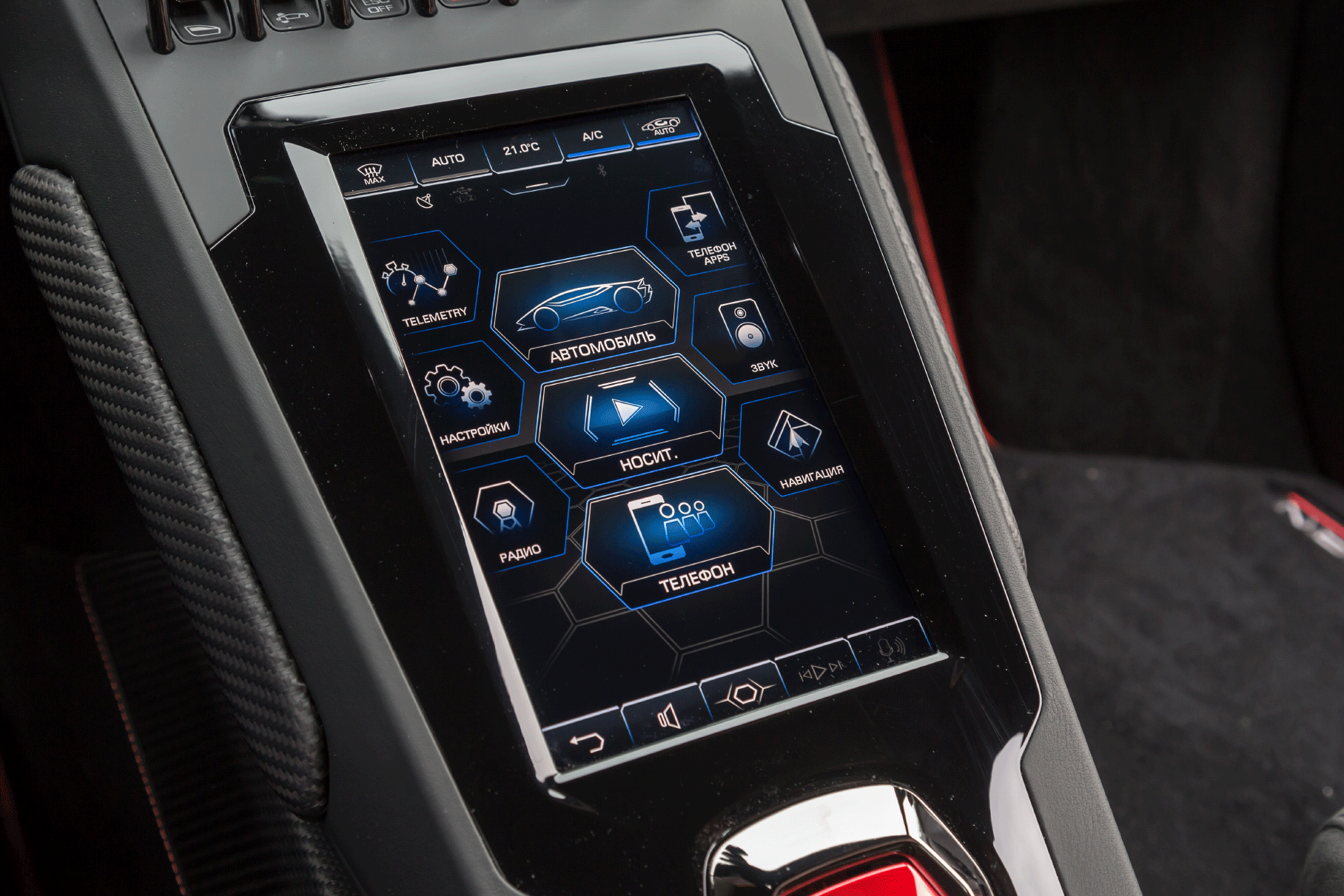 Интерфейс мультимедийной системы, как и многое в дизайне Huracán Evo, подчинён теме шестиугольника. Необычно, что всё управление аудиосистемой (которую я не включил ни разу) отдано этому сенсорному дисплею — ни на руле, ни на консоли нет ни одной механической клавиши, даже Mute