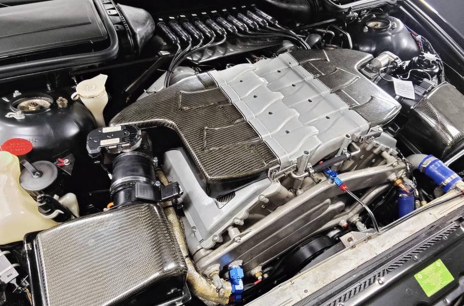 Непривычная картина под капотом BMW. Часть впуска изготовлена из углепластика, под лобовым стеклом видно быстроразъёмные соединения для подключения двигателя к бортовой электронике